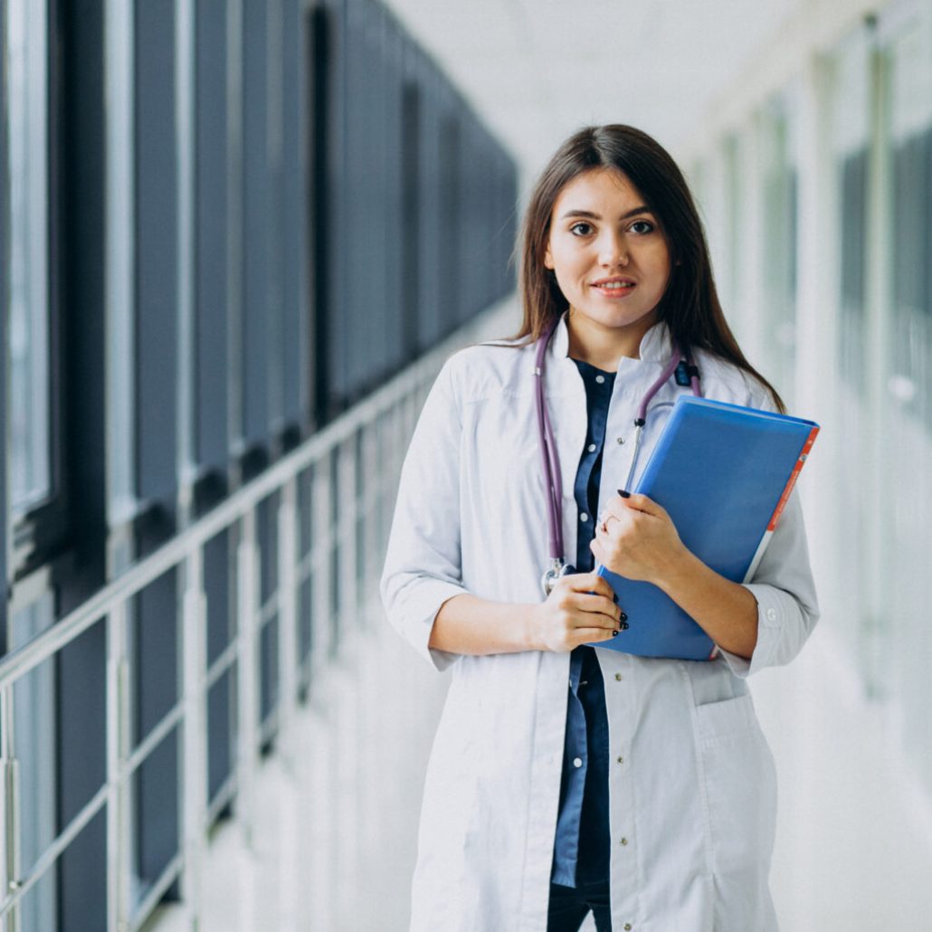 Attractive female doctor standing with documents at the hospital